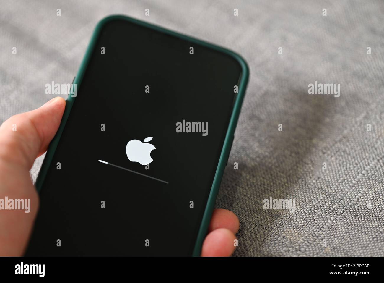IPhone 13 Pro con logo Apple caricamento e installazione del sistema operativo ios 15,5 sul primo piano dello schermo, nuovo ios 2022 sui dispositivi Apple sub v. ios 15 per Foto Stock