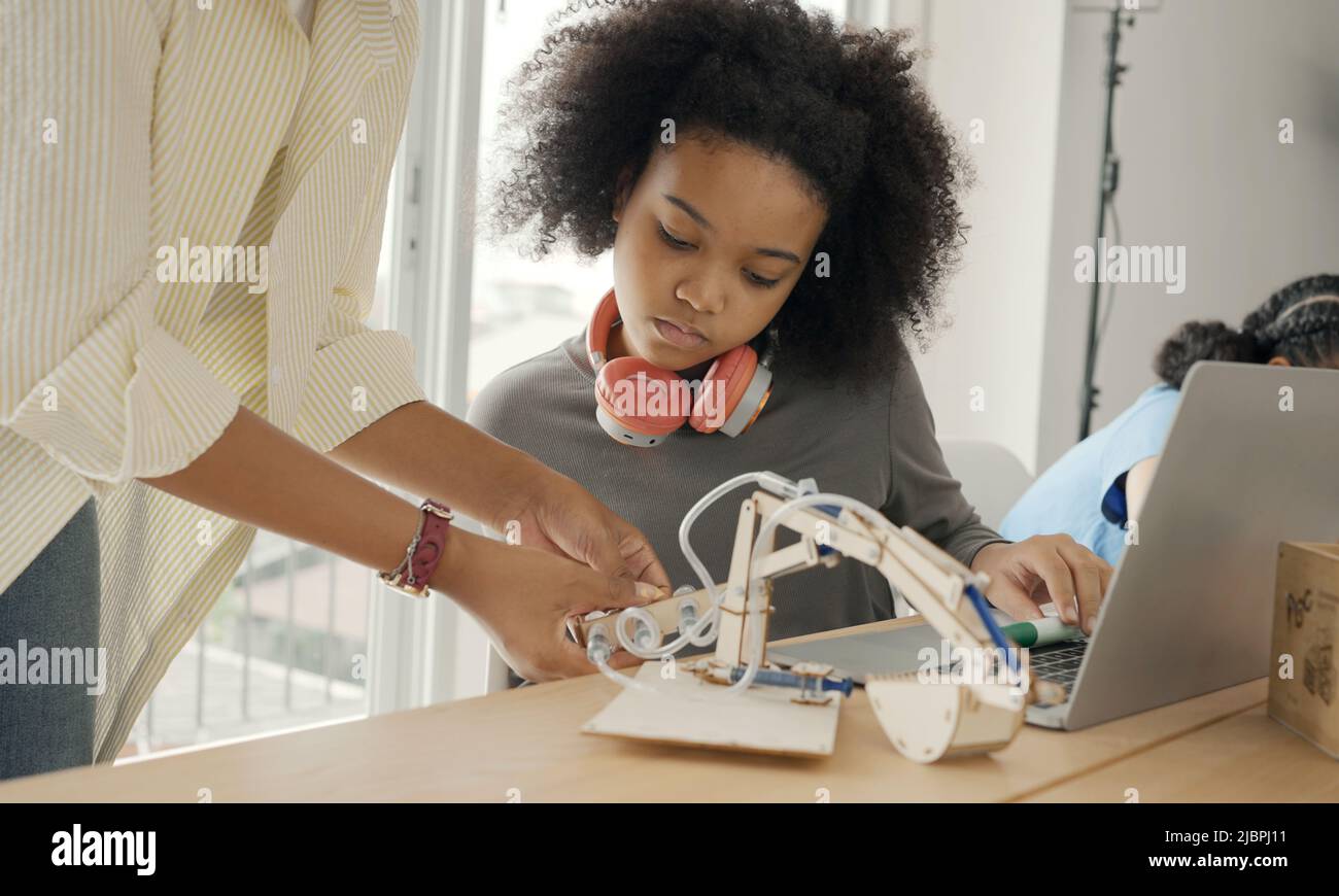 Classe con diversi studenti di studenti felicemente afroamericani e insegnanti che svolgono attività insieme. L'insegnante sta insegnando, guidando e talki Foto Stock