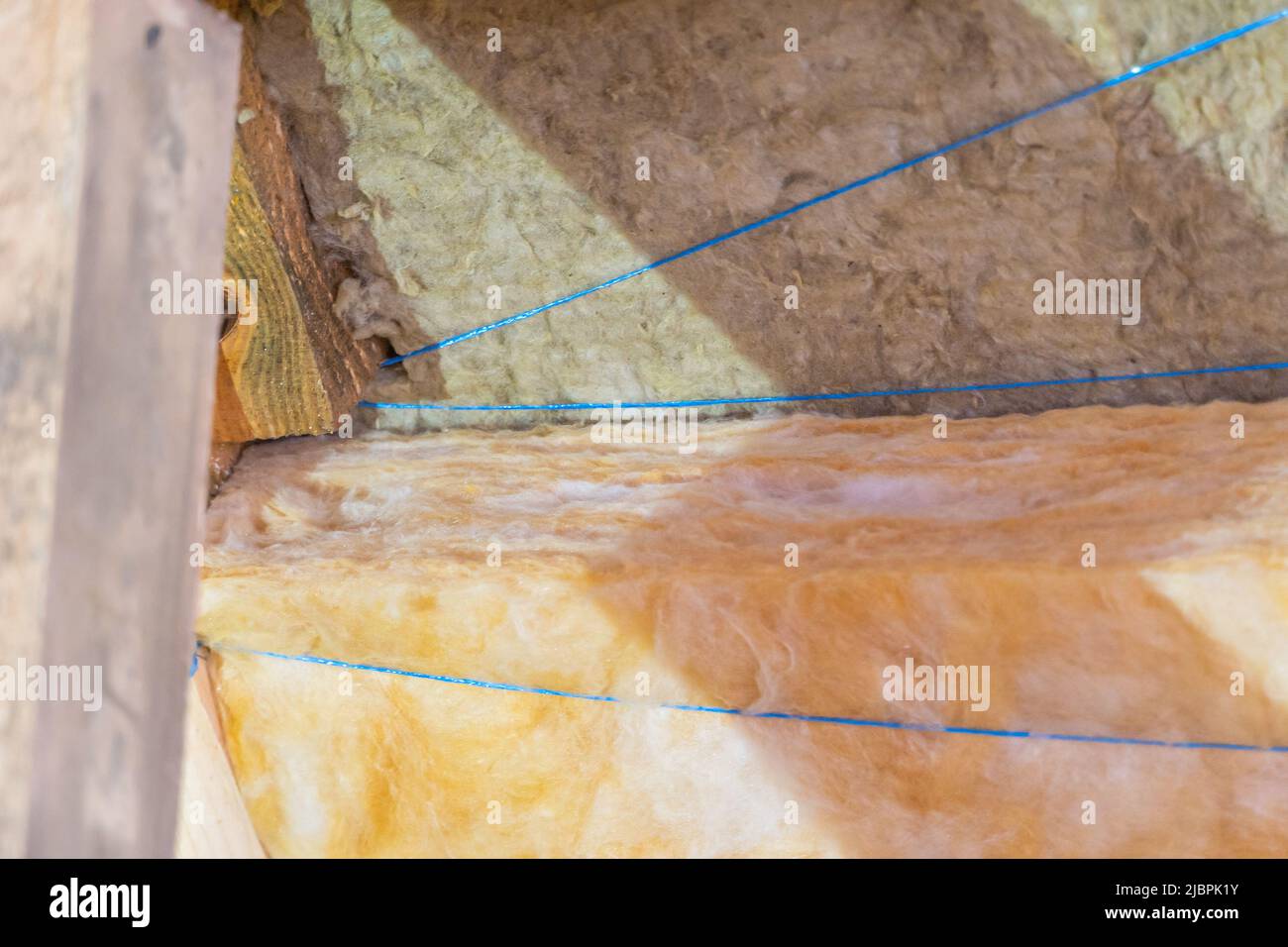 Isolamento del tetto in due strati di lana minerale e di lana di vetro si sovrappongono Foto Stock