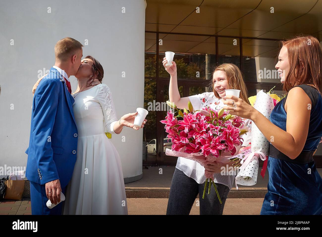 Kirov, RUSSIA - 10 agosto 2021: La sposa e lo sposo presso l'ufficio del registro dopo la cerimonia ufficiale del matrimonio e persone, amici, parenti Foto Stock