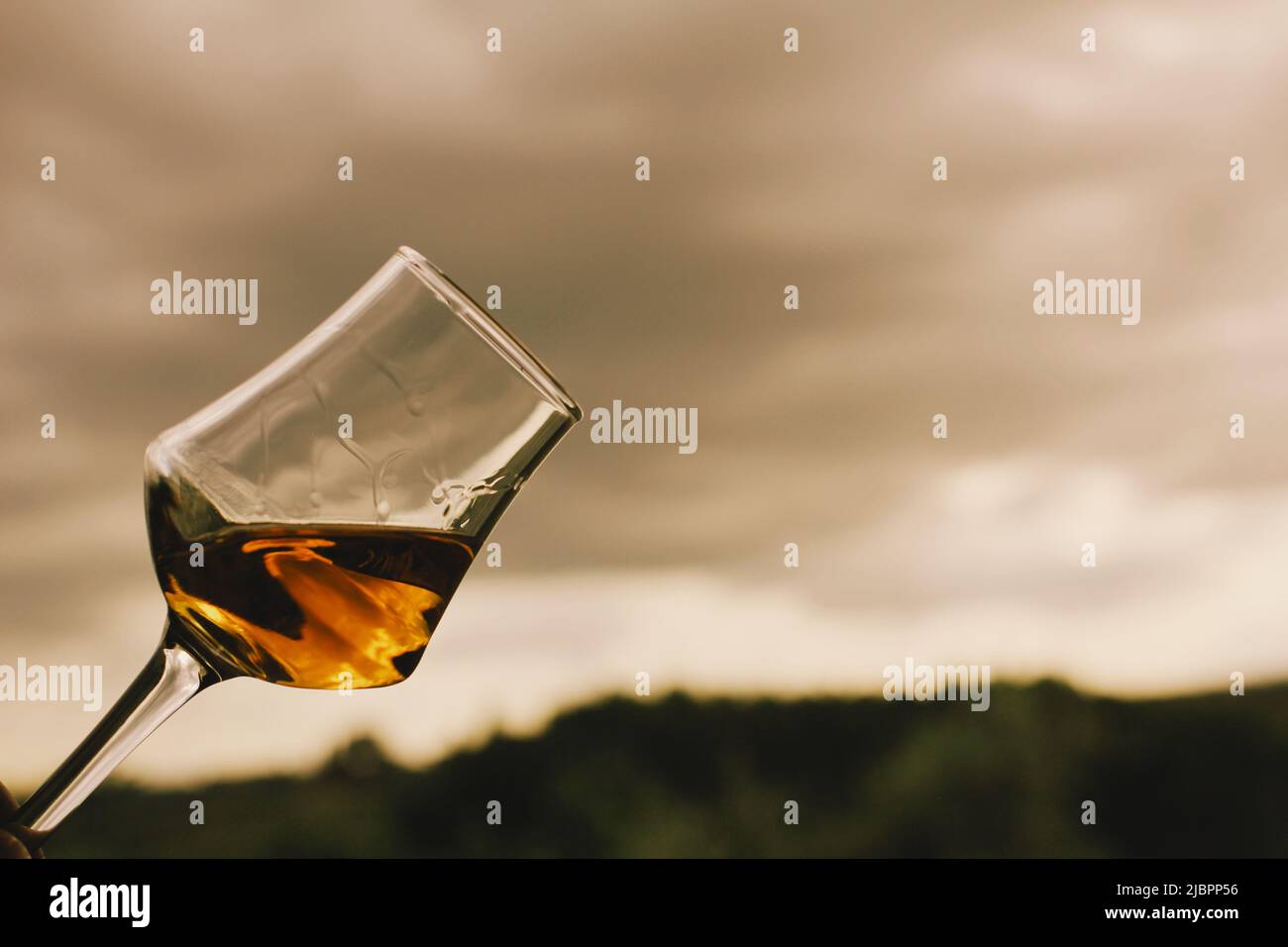 Bicchiere di vino dolce con un cortile toscano come sfondo. Foto Stock