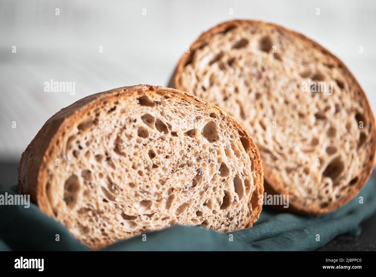 Il processo di produzione del pane di grano a casa. Una fetta di pane fatto in casa. Il concetto di cibo sano fatto in casa. Vista frontale. Foto Stock