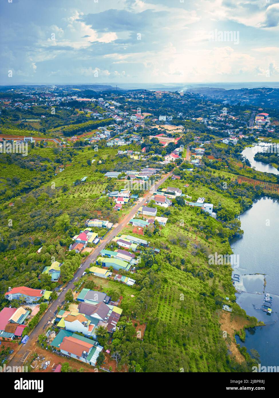 Veduta aerea della strada Nazionale 14 nella città di Kien Duc, provincia di DAC Nong, Vietnam con paesaggio collinare, popolazione sparsa intorno alle strade e Dak R'tang Foto Stock