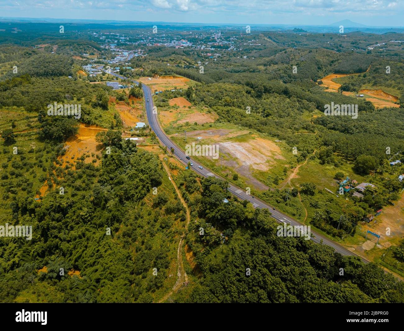 Veduta aerea della strada Nazionale 14 nella provincia di Binh Phuoc, Vietnam con paesaggio collinare e popolazione sparsa intorno alle strade. Viaggi e paesaggio con Foto Stock