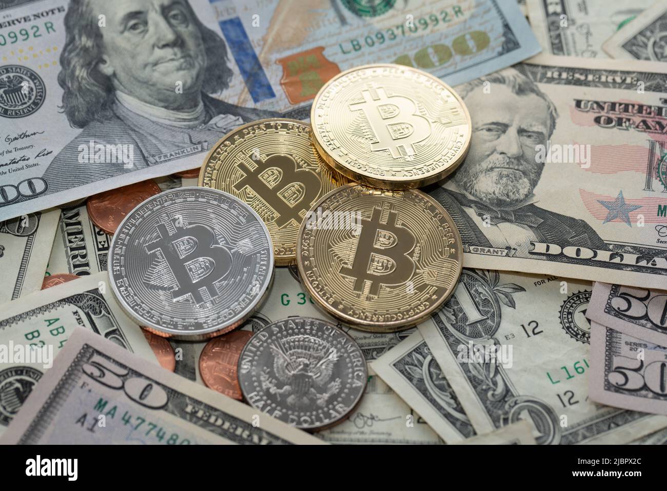 Monete in Bitcoin su banconote in dollari, banconote in cinquanta e cento dollari. Valuta USA e valuta BTC Crypto Foto Stock