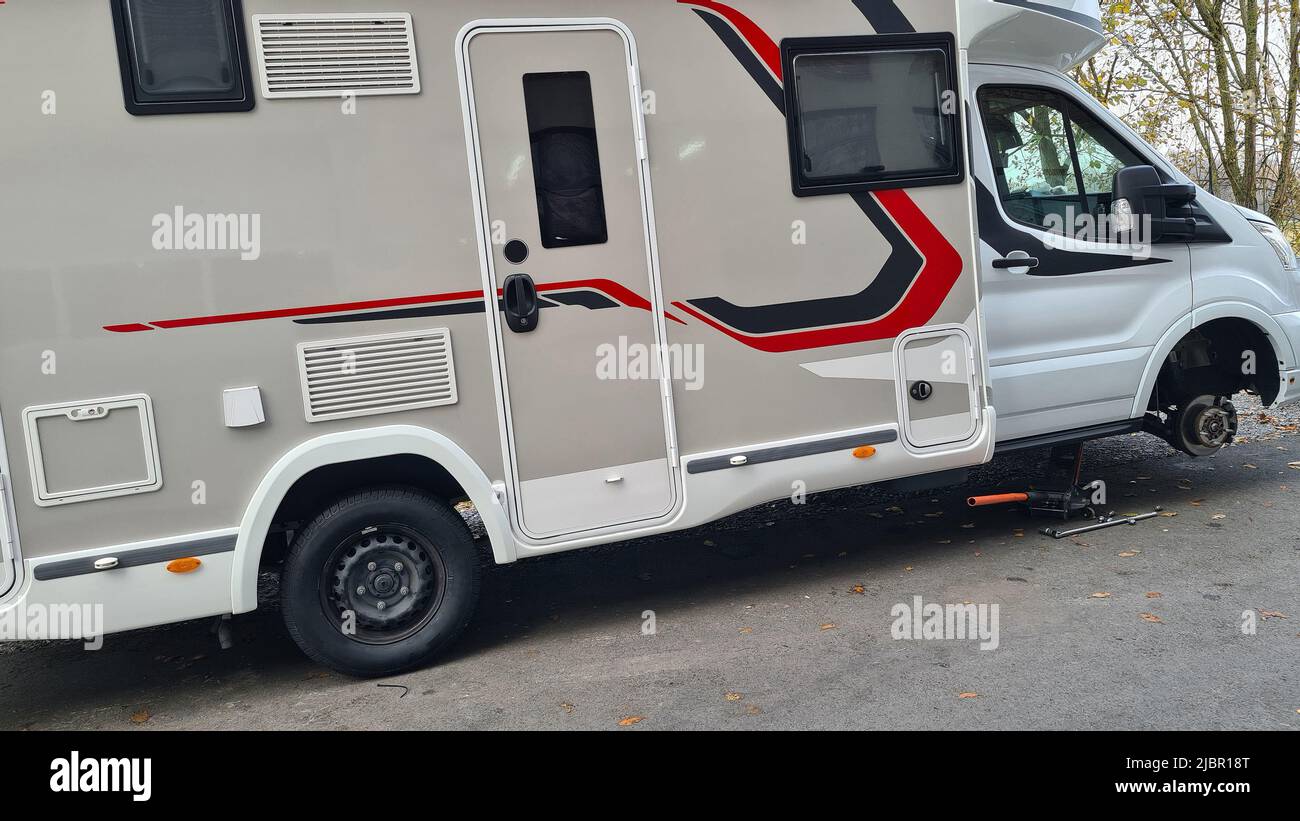 Camper o camper che cambiano pneumatici in officina dall'inverno all'estate o per tutte le stagioni Foto Stock