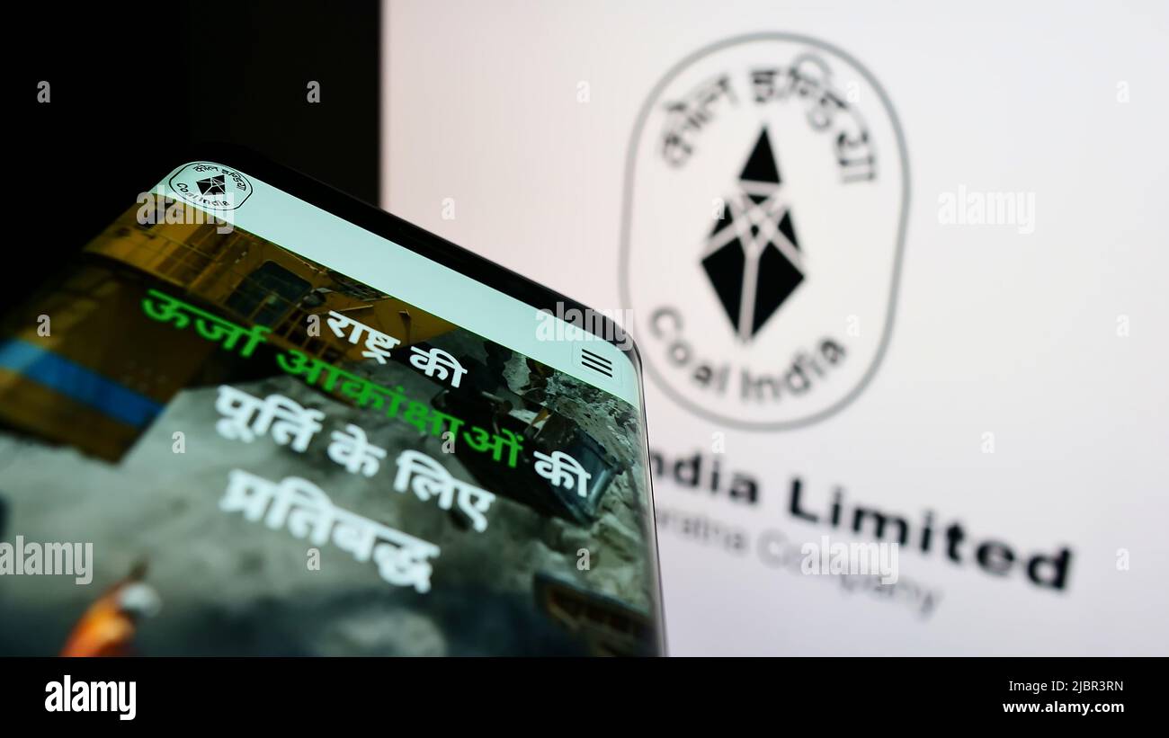 Smartphone con sito web della società mineraria Coal India Limited (CIL) sullo schermo di fronte al logo aziendale. Mettere a fuoco sulla parte superiore sinistra del display del telefono. Foto Stock