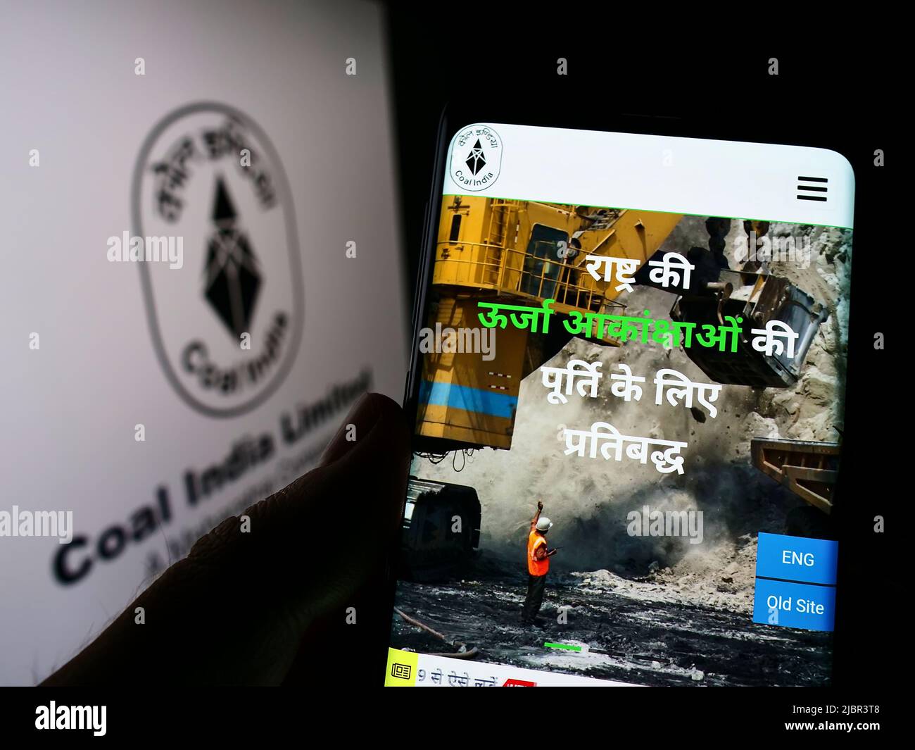 Persona che tiene il cellulare con pagina web della società mineraria Coal India Limited (CIL) sullo schermo di fronte al logo. Concentrarsi sul centro del display del telefono. Foto Stock
