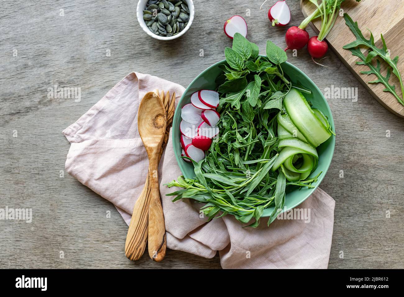 Estate cibo sano. Il fundament verde di base per un'insalata con ravanello e cetrioli. Spazio di copia per testo o ricetta. Foto Stock