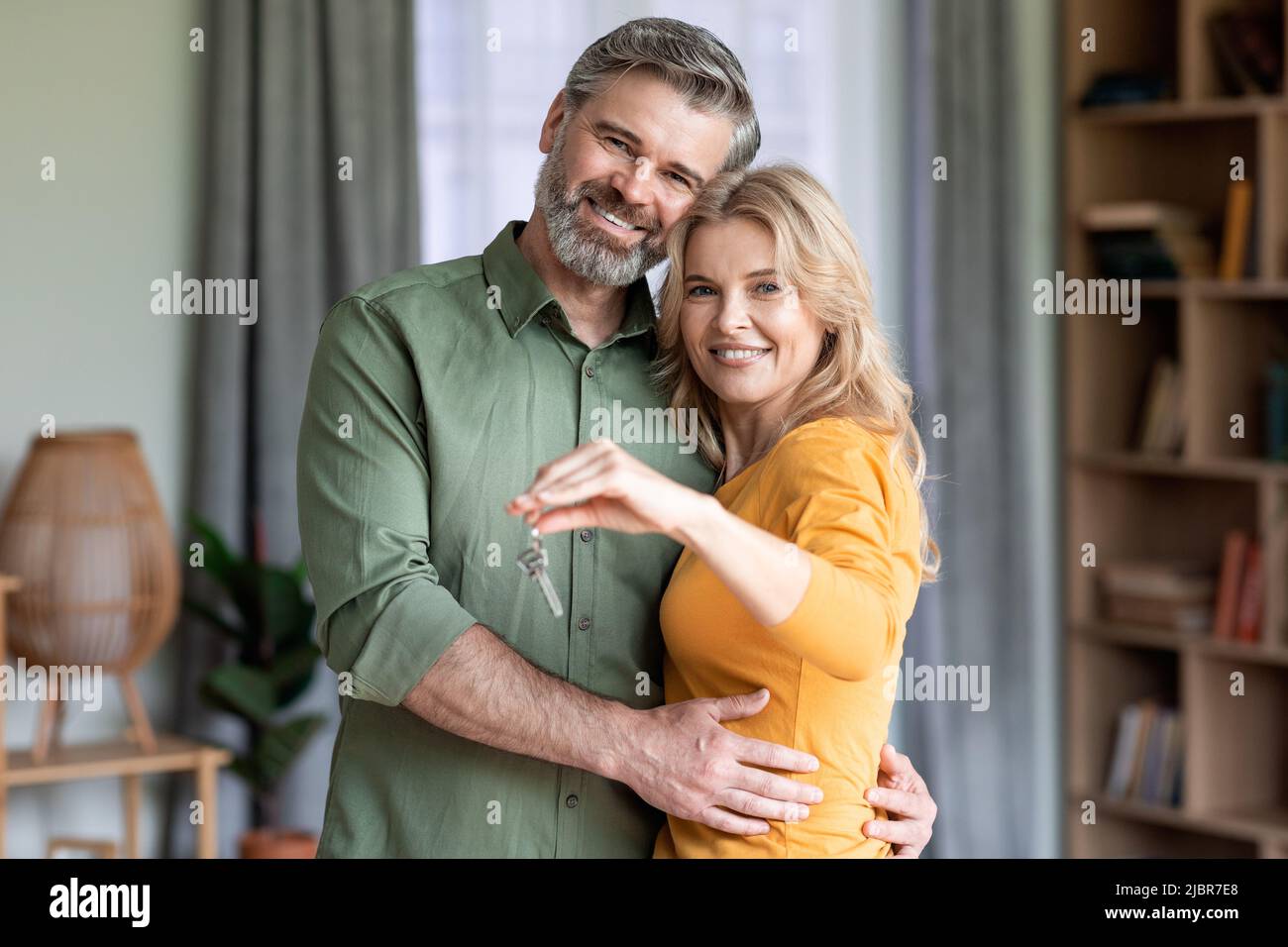 Felice coppia di mezza età che tiene le chiavi di casa e sorridente Foto Stock