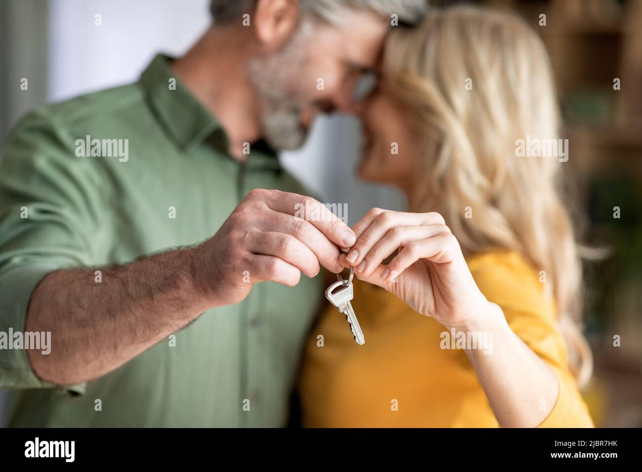 Primo piano Shot di Romantico Medio Age Coppia tenendo in mano le chiavi di casa Foto Stock