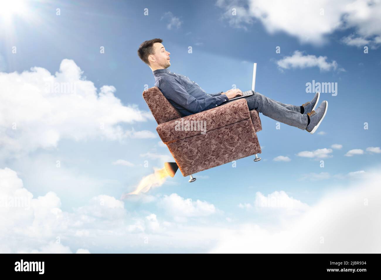 L'uomo che utilizza un computer portatile vola attraverso il cielo Foto Stock