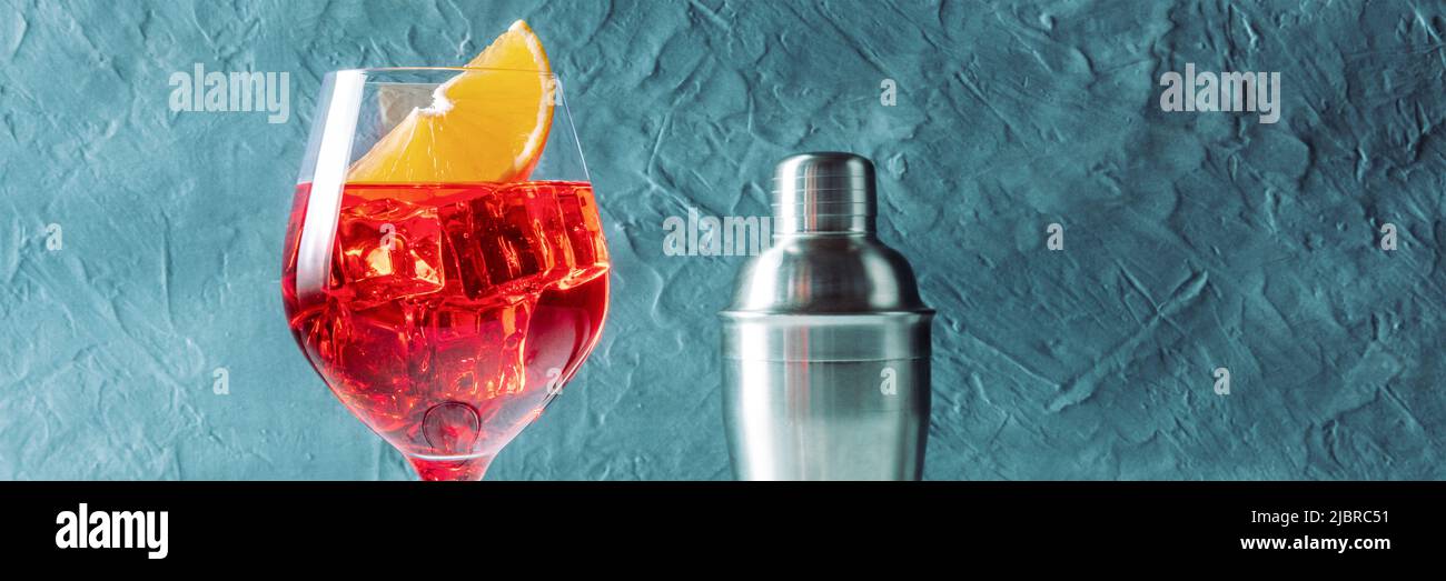 Cocktail Aperol con panorama arancione, vista laterale con shaker su sfondo blu, con un posto per il testo Foto Stock