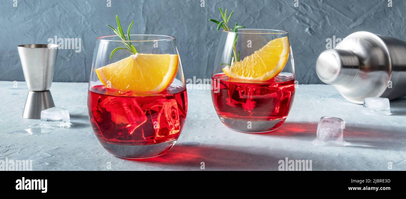 Cocktail Campari con arance fresche, rosmarino, un jigger e uno shaker, un panorama mixologico Foto Stock