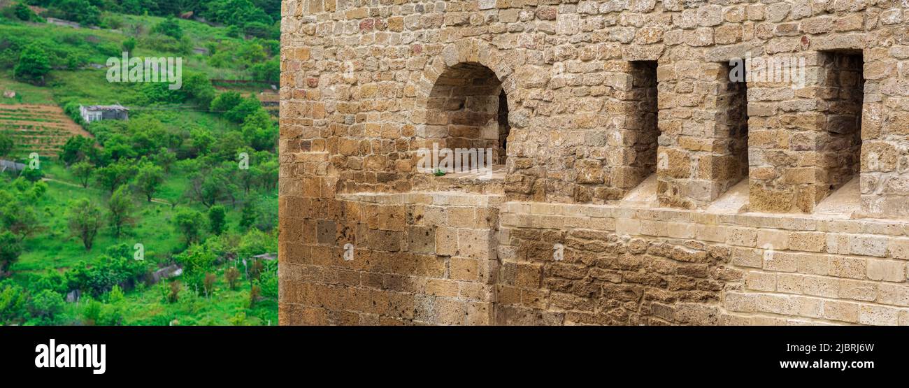 Frammento del muro di un castello medievale, dietro il quale sono visibili i fauborghi; Cittadella di Naryn-Kala a Derbent Foto Stock