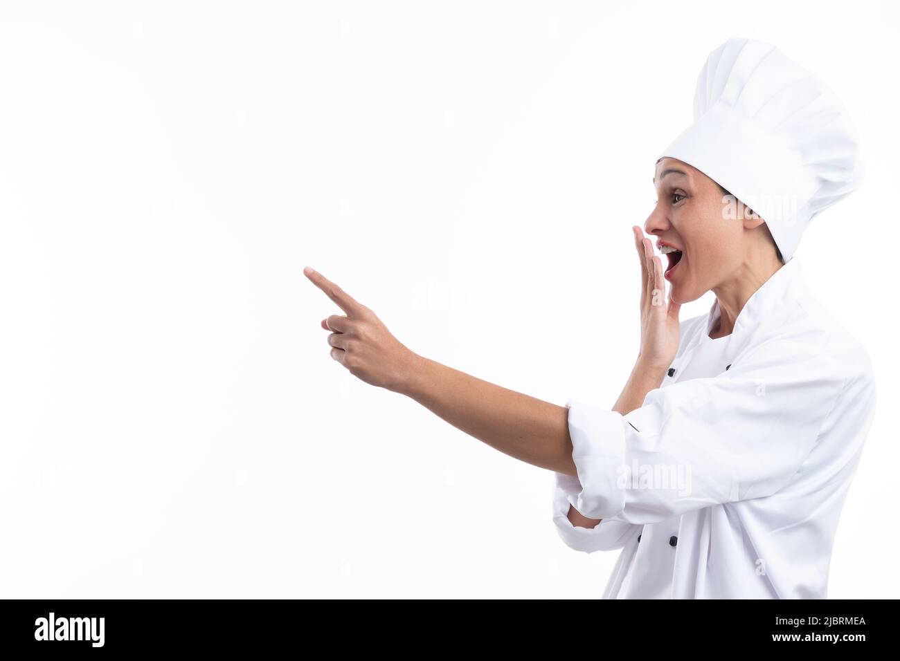 Donna chef sorpreso puntando con dito isolato su sfondo bianco con spazio copia . Foto Stock
