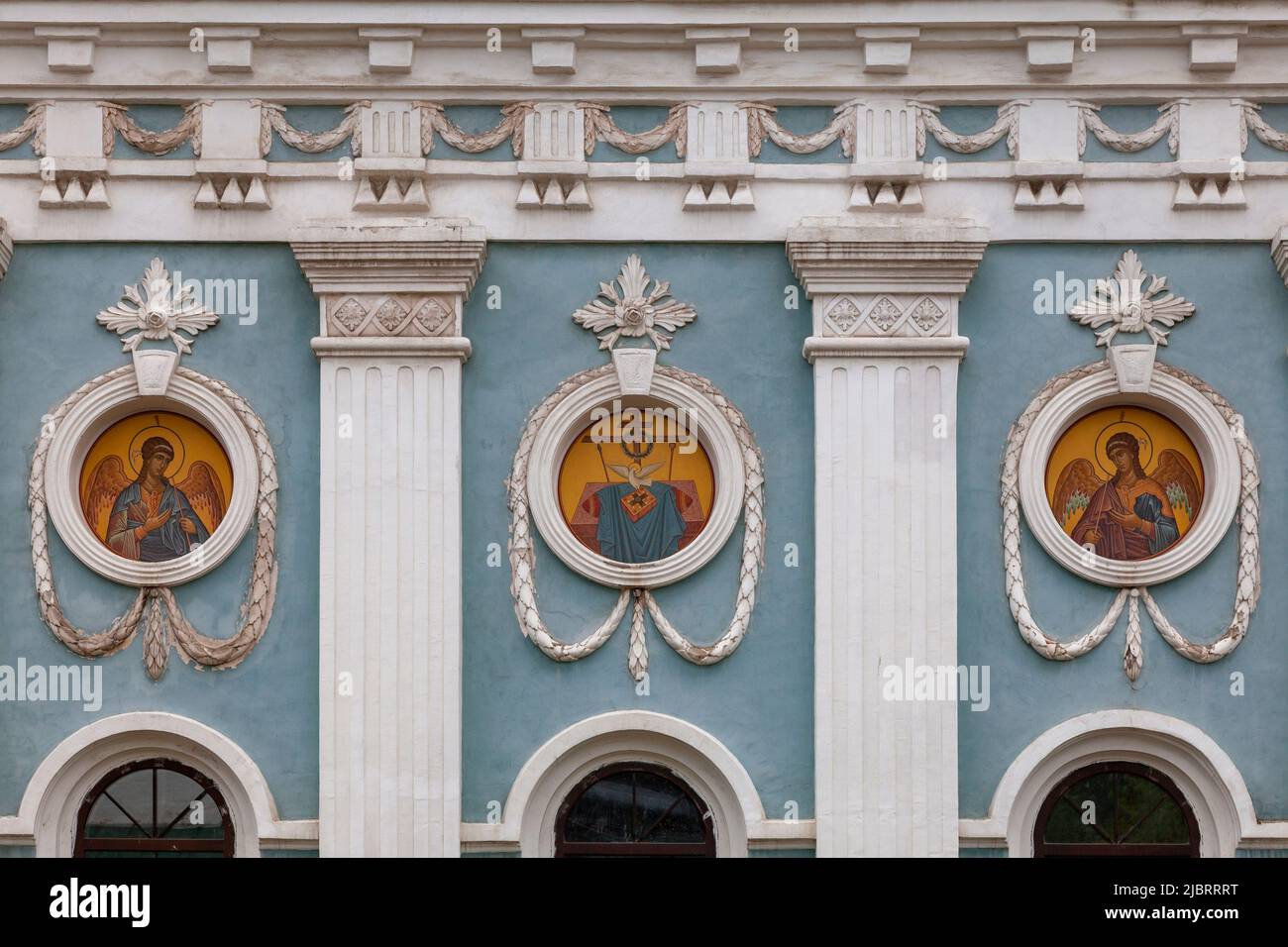 Un frammento del muro di una chiesa ortodossa con icone rotonde e un modello stucco. Foto Stock