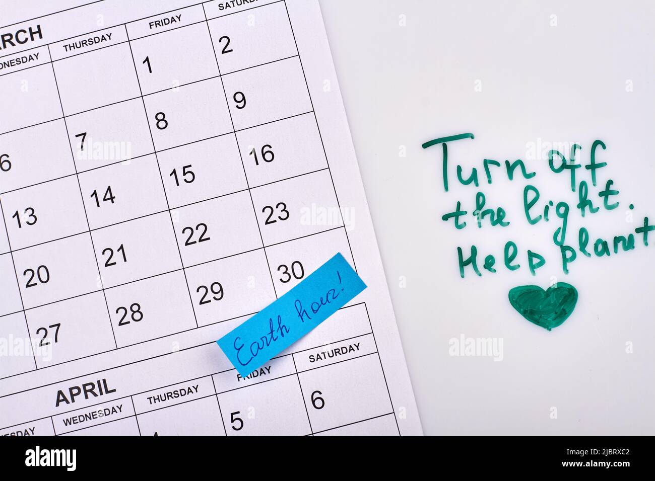 Spegnere la guida luminosa. Concetto di ora di terra. Calendario cartaceo su sfondo bianco. Foto Stock