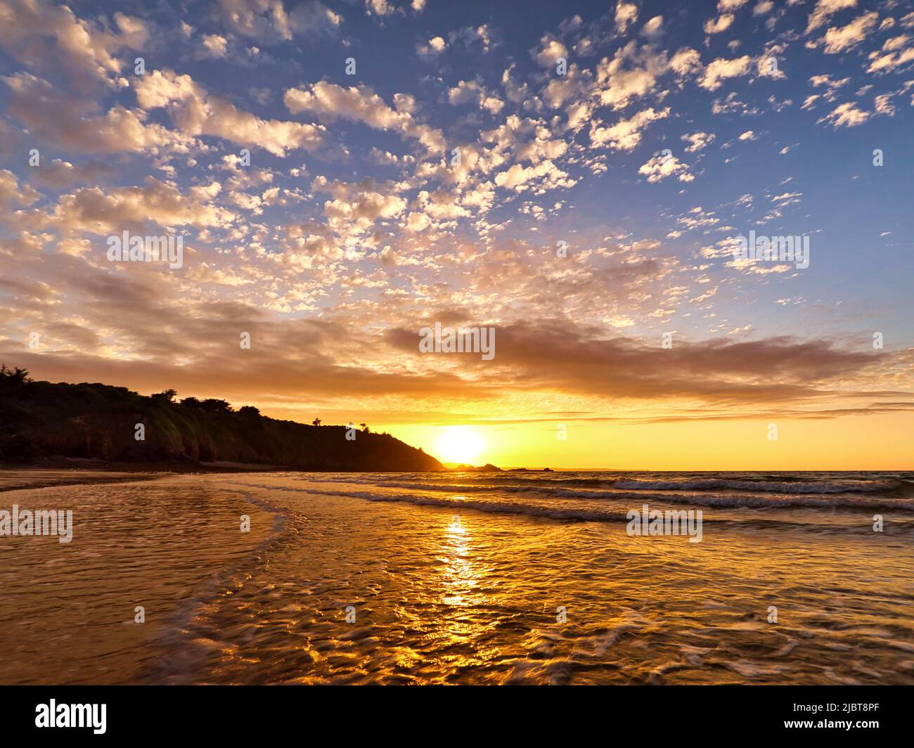Francia, Côtes d'Armor, Baia di Saint-Brieuc, tramonto sulla spiaggia, riflesso del sole sulle onde e il mare Foto Stock