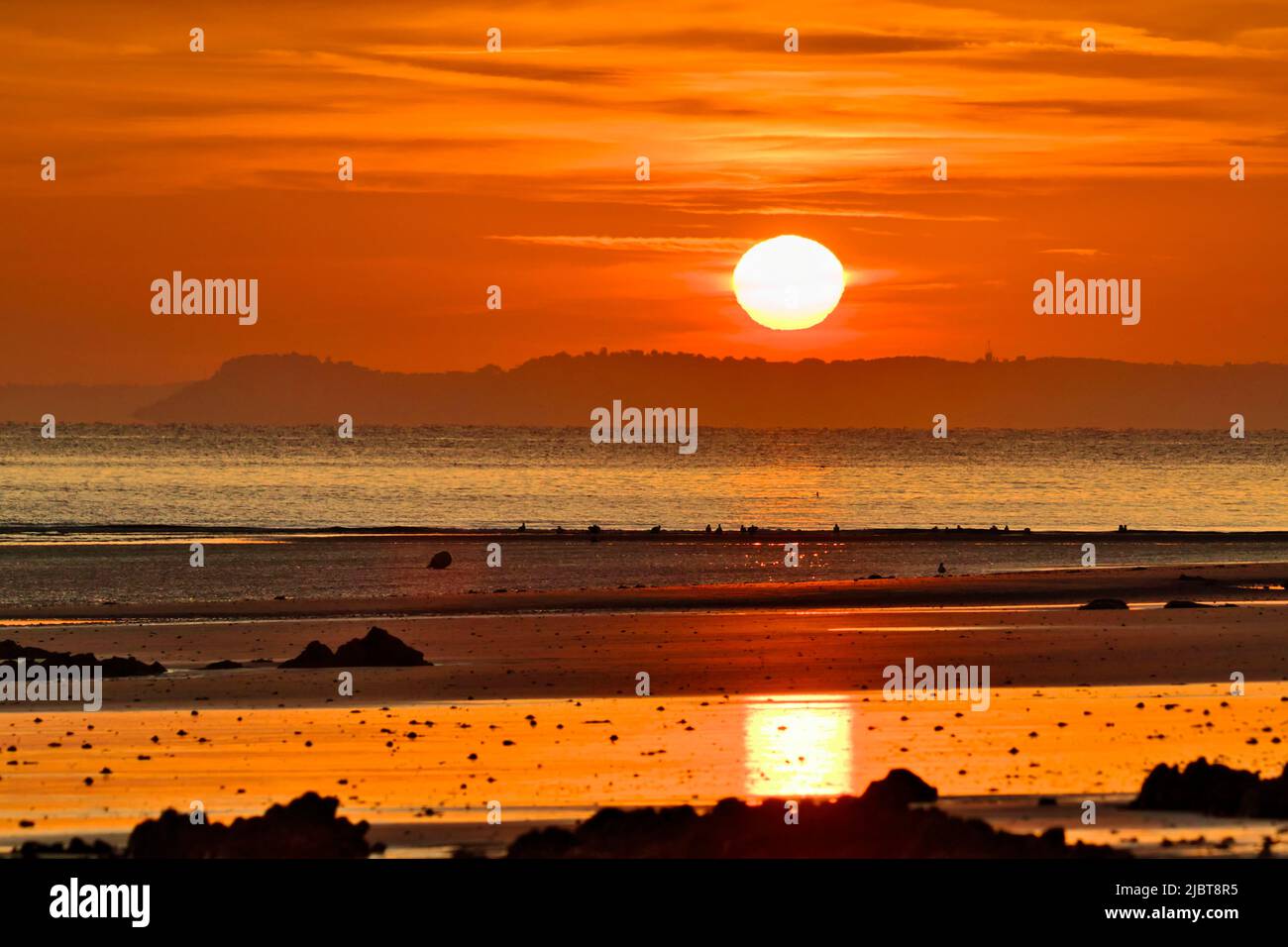 Francia, Côtes d'Armor, Baia di Saint-Brieuc, alba sulla spiaggia, riflesso del sole sulle onde e il mare Foto Stock
