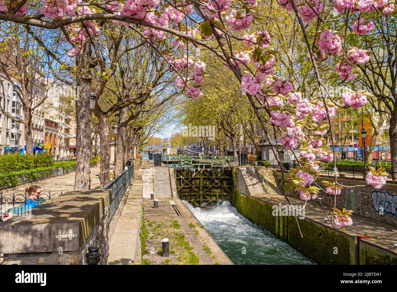 Francia, Parigi, canale di Saint Martin, serratura dei morti e un ciliegio in fiore, Quai de Valmy Foto Stock