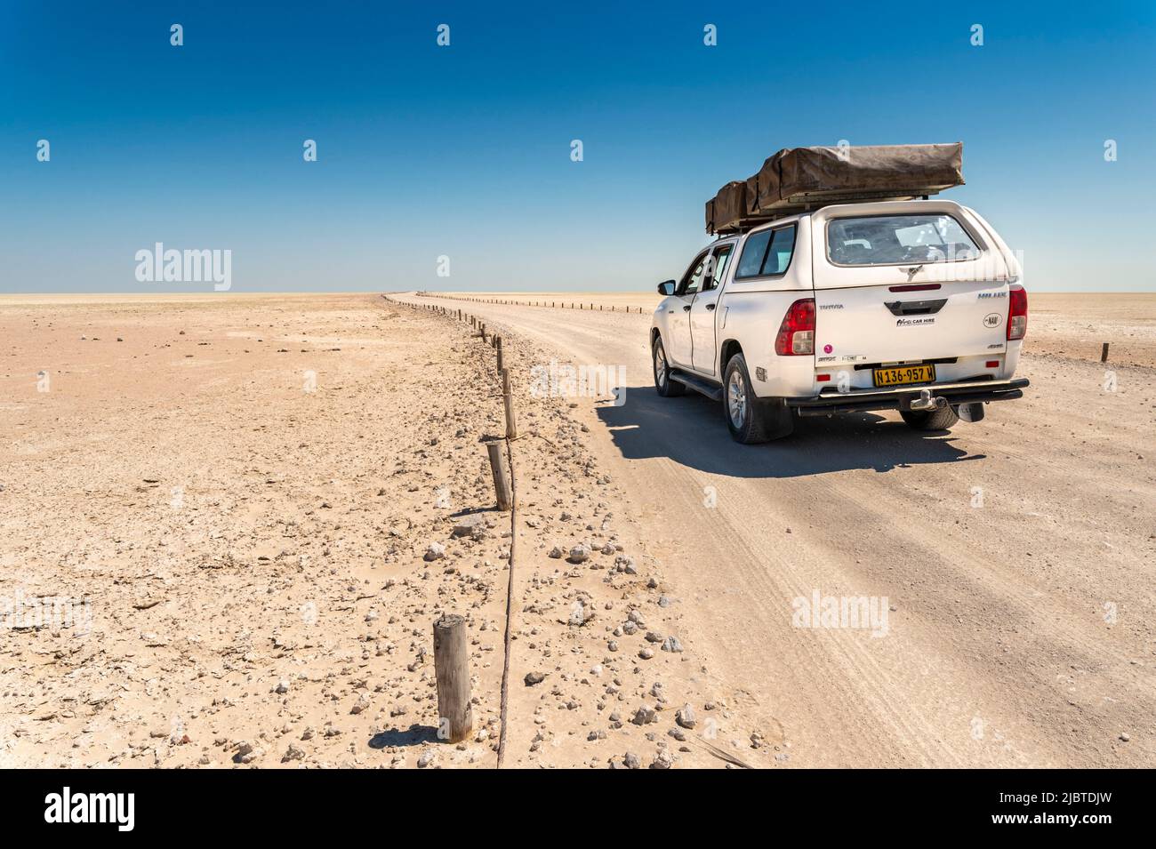 Namibia, la regione di Kunene, il Parco Nazionale Etosha, 4x4 che guida la pista sulla vasta salina Foto Stock