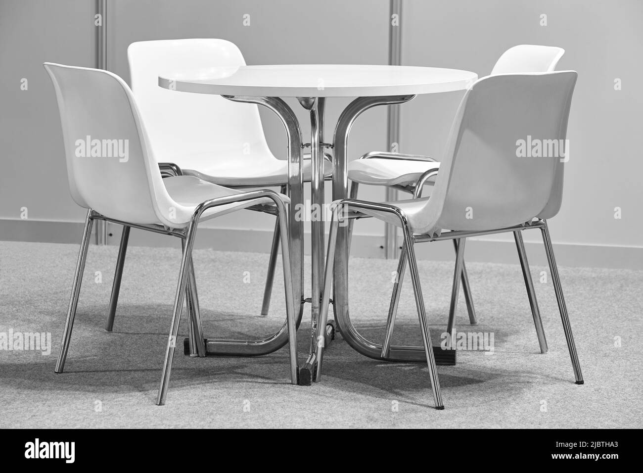 Sedie bianche e tavolo interno set. Arredamento moderno e confortevole in plastica Foto Stock