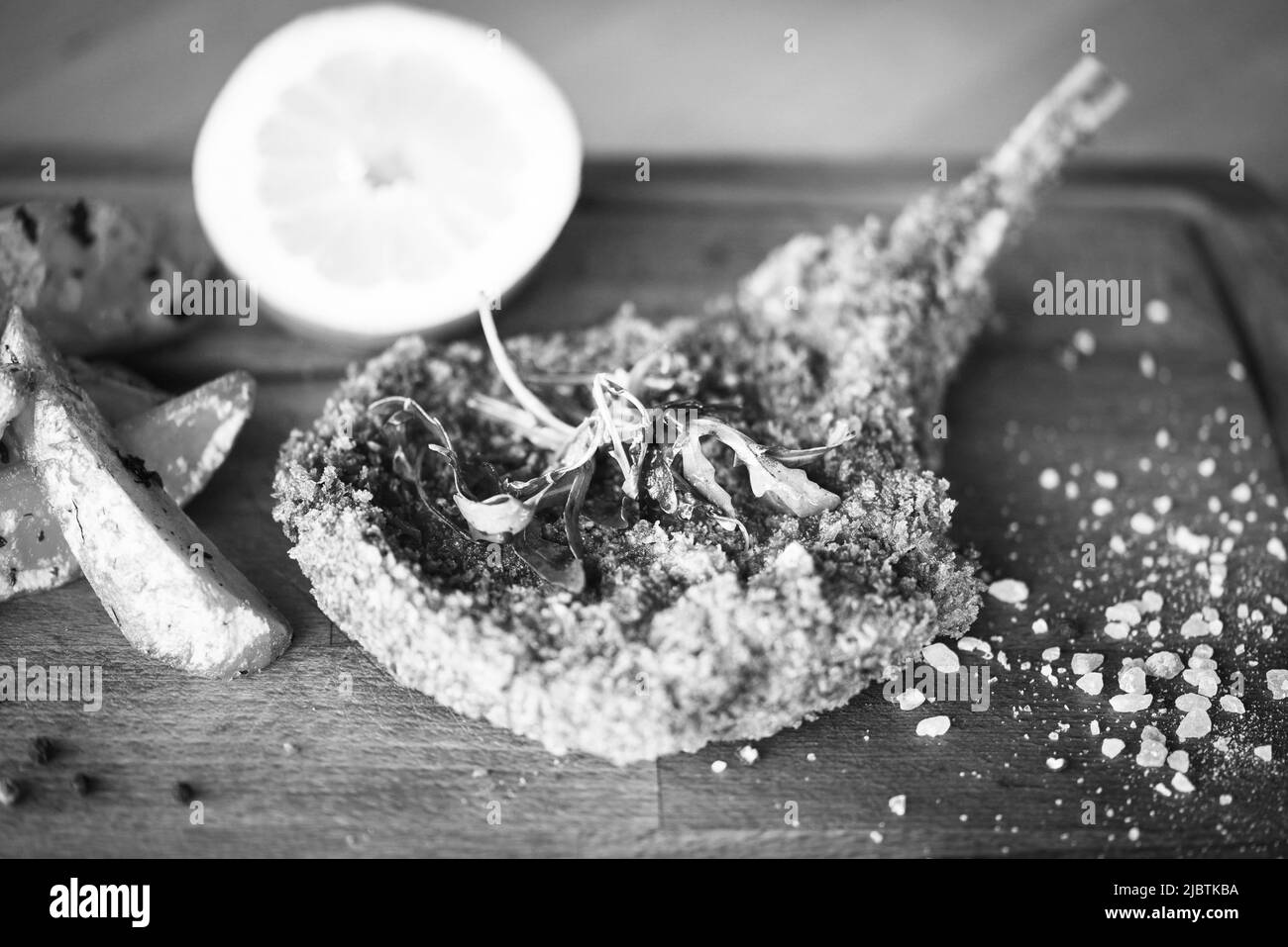 delizioso scnitzel di maiale panko croccante con spicchi e pepe fresco Foto Stock