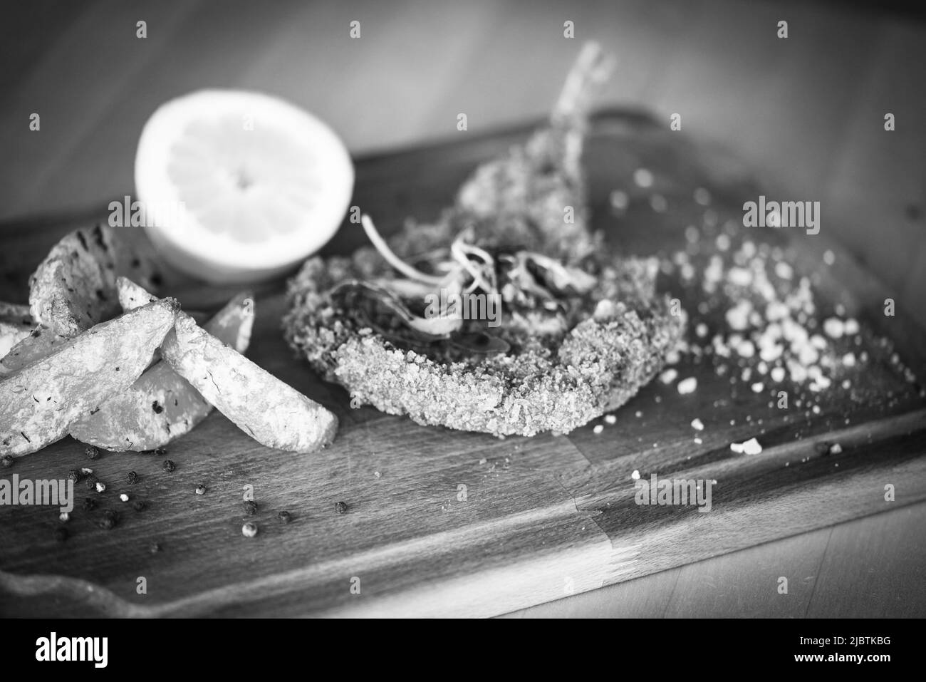 delizioso scnitzel di maiale panko croccante con spicchi e pepe fresco Foto Stock