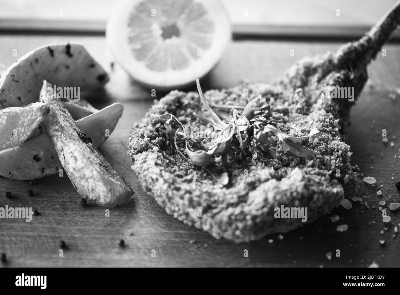 delizioso scnitzel di maiale panko croccante con spicchi e pepe fresco Foto Stock