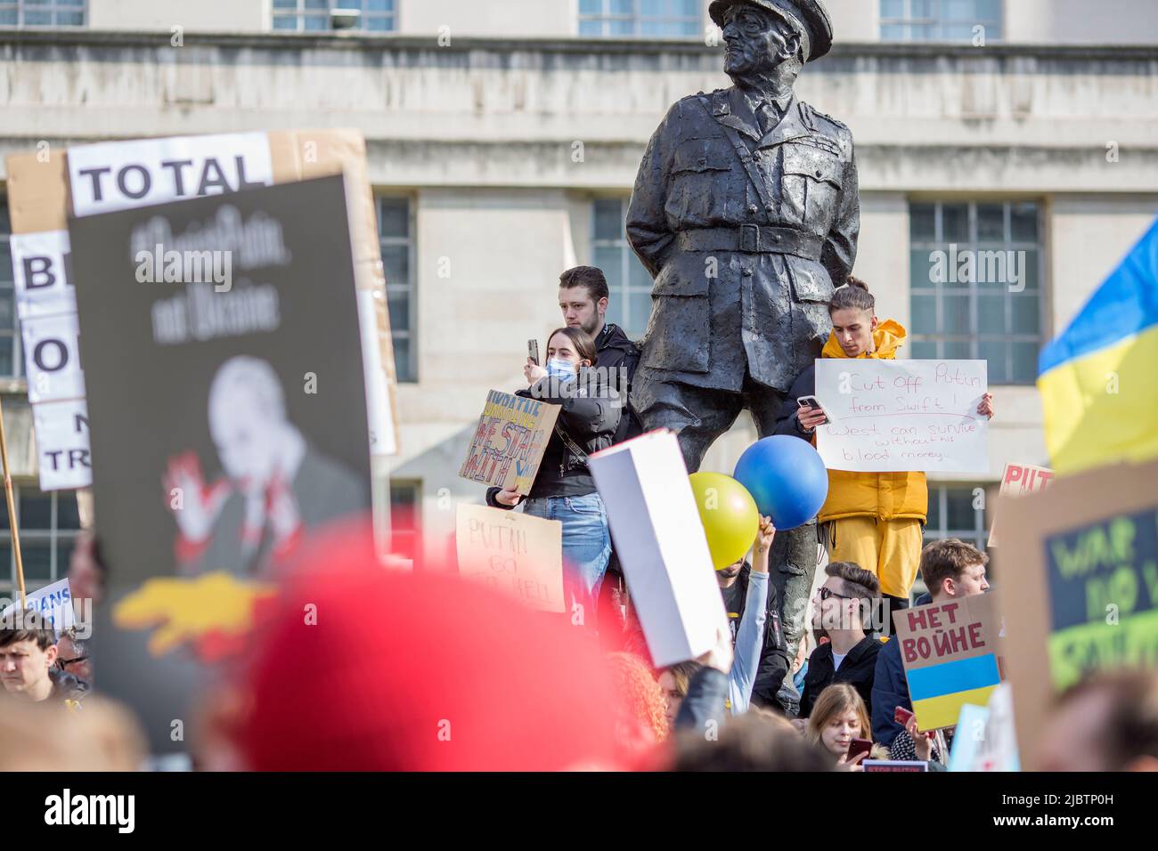 I partecipanti si riuniscono durante il “Stand with Ukraine!” Protesta a sostegno del paese vicino Downing Street nel centro di Londra. Foto Stock