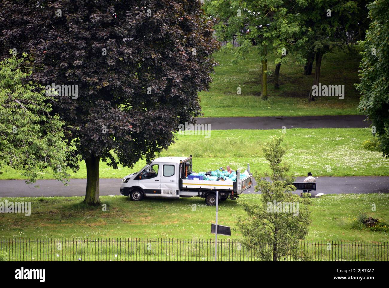 Manchester, Regno Unito, 8th giugno 2022. Vista dall'alto. Un addetto alla raccolta rifiuti raccoglie rifiuti nell'Ardwick Green Park, di proprietà del Manchester City Council, Inghilterra, Regno Unito, Isole britanniche. Fornitura di servizi da parte delle amministrazioni locali. I tre sindacati del governo locale, Unite, UNISON e GMB, hanno presentato una richiesta di retribuzione per il personale in Inghilterra, Galles e Irlanda del Nord per ricevere un aumento di retribuzione di £2.000 ciascuno o il tasso attuale di RPI (attualmente 11,1%), a seconda di quale sia più alto per ciascun individuo. Credit: Terry Waller/Alamy Live News Foto Stock
