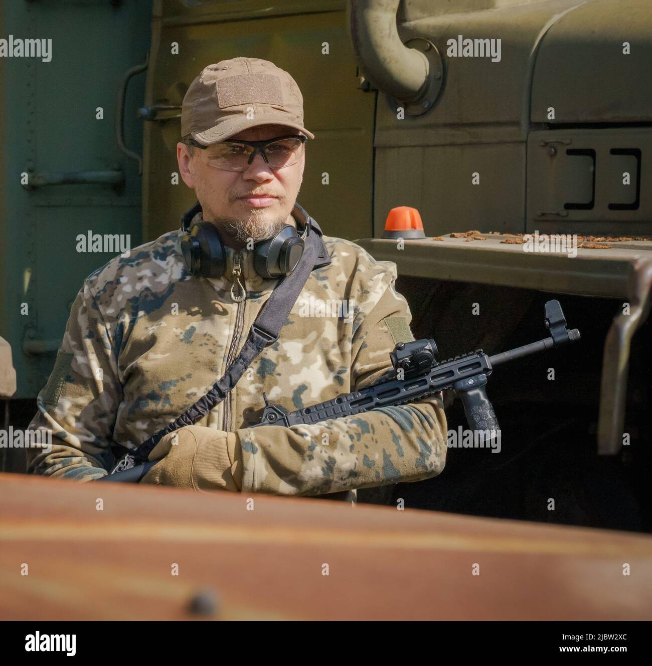 L'uomo militare ucraino si trova in guardia con l'arma nelle mani per proteggere i civili. Soldato di forze speciali. L'uomo in munizioni militari è in guardia. Ranger durante l'operazione militare. Foto Stock