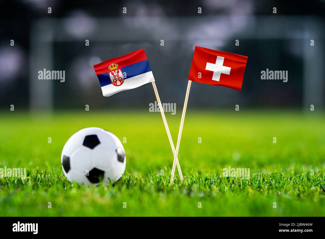 Serbia vs Svizzera, Stadio 974 carta da parati partita di calcio, Bandiere nazionali fatte a mano e pallone da calcio su erba verde. Stadio di calcio in background. Foto Stock