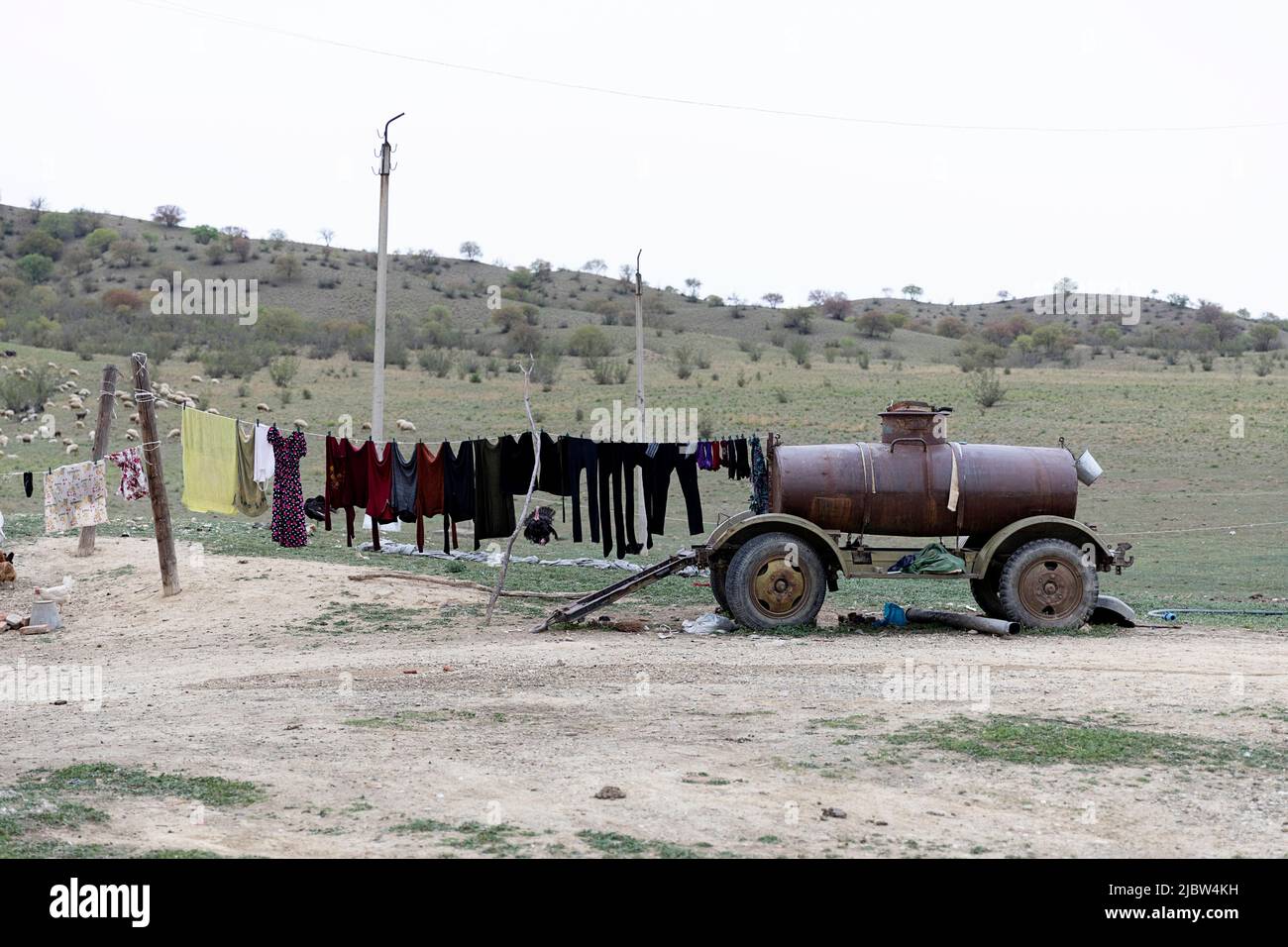Vestiti appesi su una linea di corde attaccati ad un vecchio veicolo agricolo, su una fattoria vicino Dali Reservoir, Chachuna Managed Nature Reserve, Georgia Foto Stock