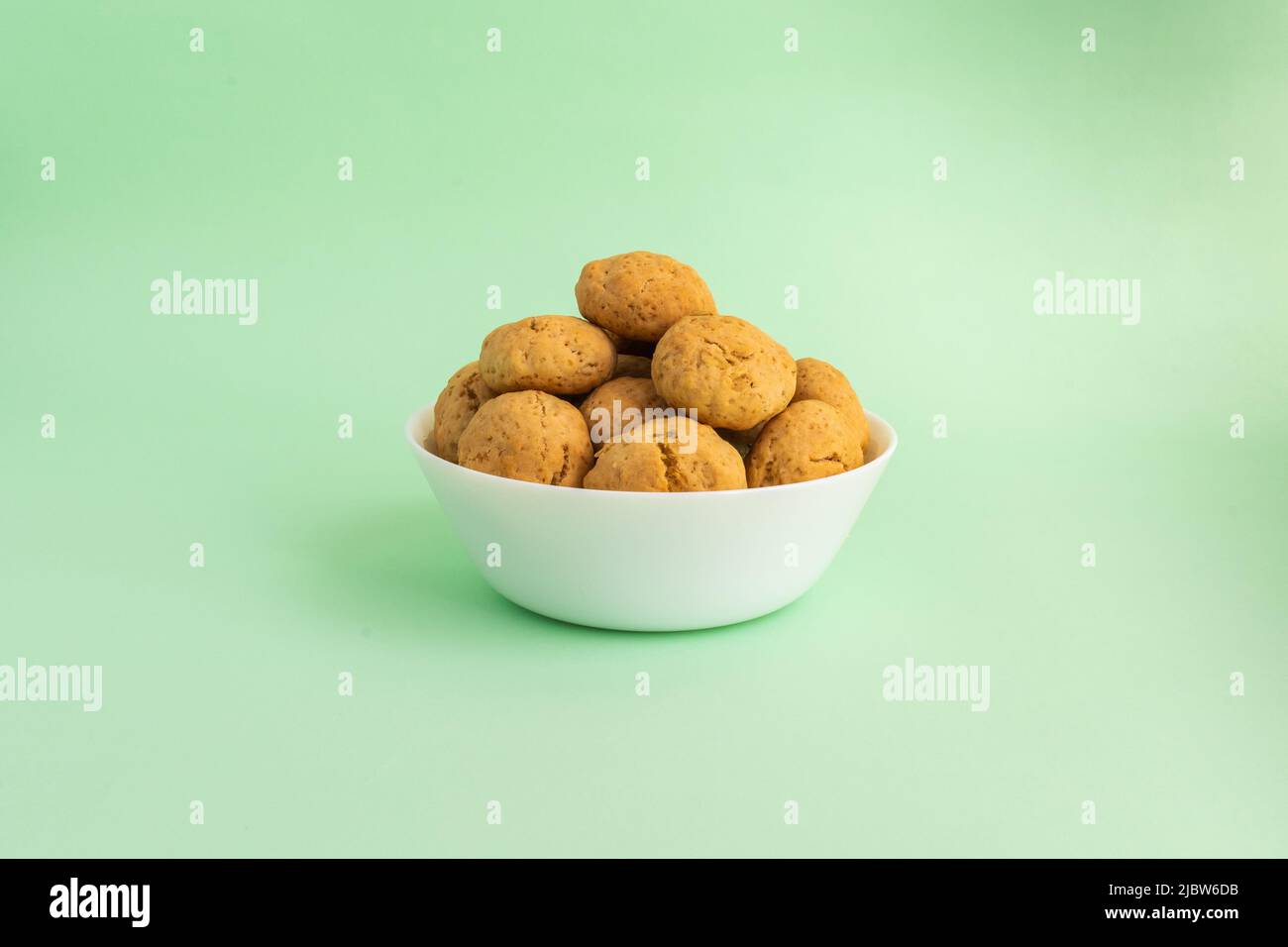 Biscotti di farina d'avena su un piatto bianco su sfondo verde. Concetto di cibo sano. Foto di alta qualità Foto Stock