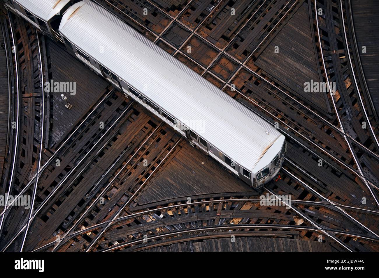 Vista ad angolo alto del treno passeggeri all'incrocio. Ferrovia sopraelevata nel centro di Chicago. Foto Stock