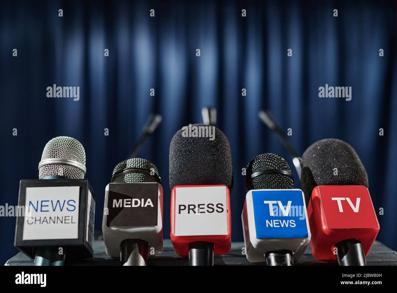 Primo piano dei microfoni di diversi supporti tv di fronte alla tribune per l'altoparlante alla conferenza stampa Foto Stock