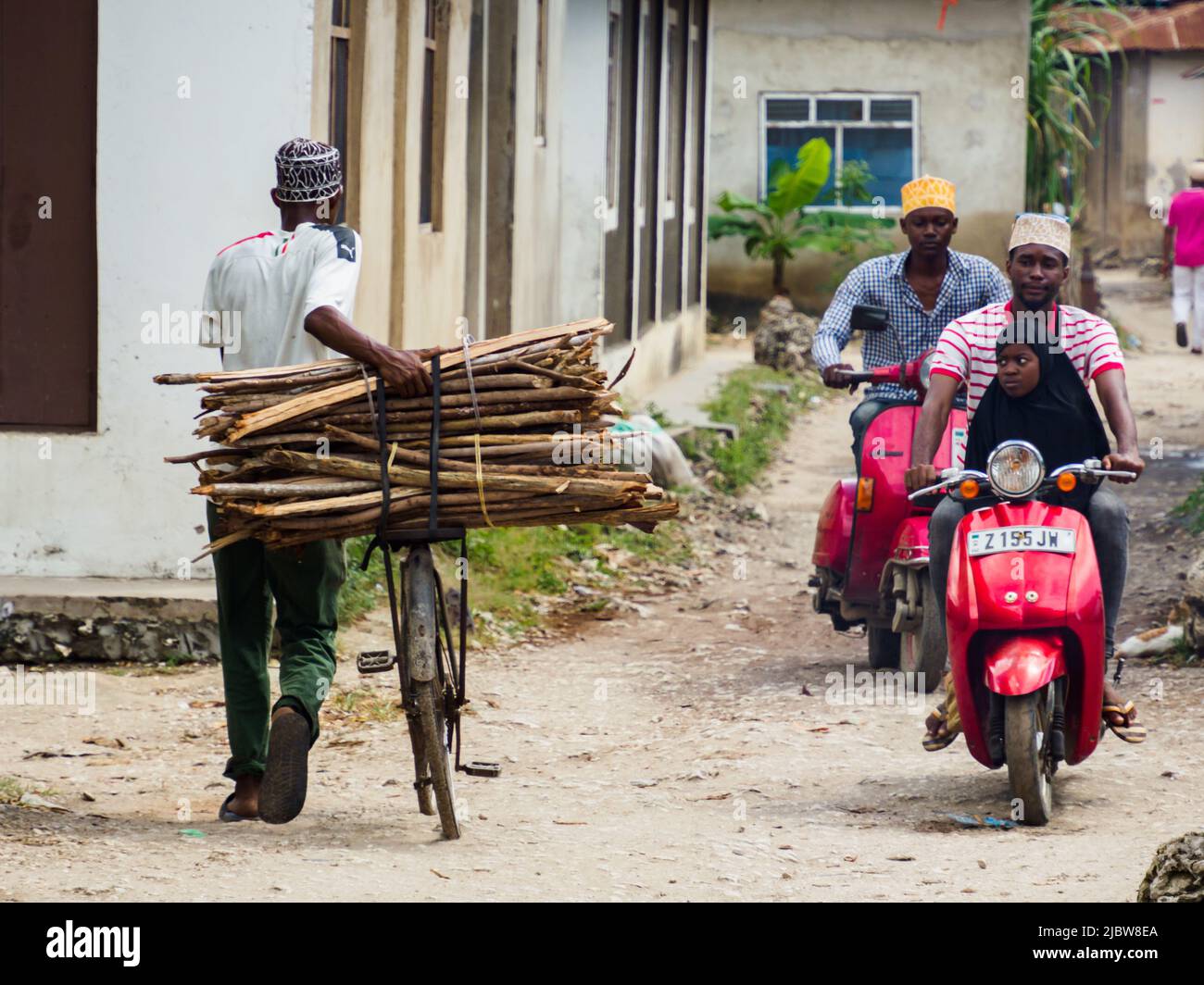 Mwanakwerekwe villaggio, Zanzibar - Feb, 2021: La bicicletta è un mezzo di trasporto molto popolare in Africa, sia per il trasporto di persone e di vario tipo Foto Stock