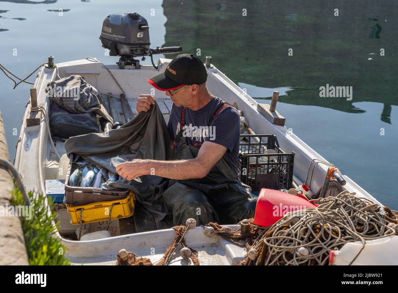 Pescatore e catture fresche nel porto della città vecchia, Dubrovnik, Croazia Foto Stock