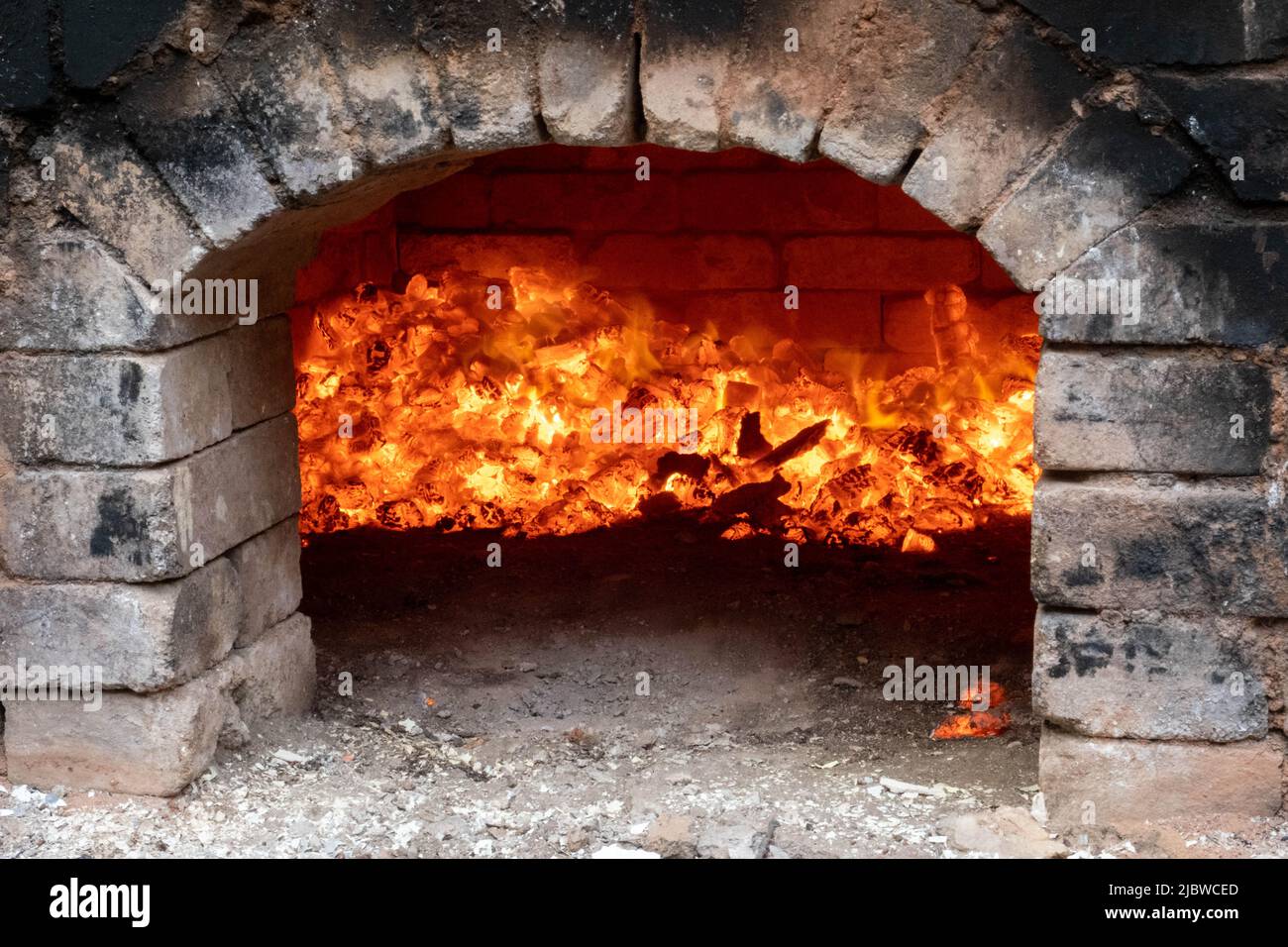 Sparare di forno di fuoco di legno fa parte del processo per la ceramica nera. Pentole e piatti unici fatti a mano di argilla che si annerono dopo la cottura e la riduzione dell'ossigeno Foto Stock