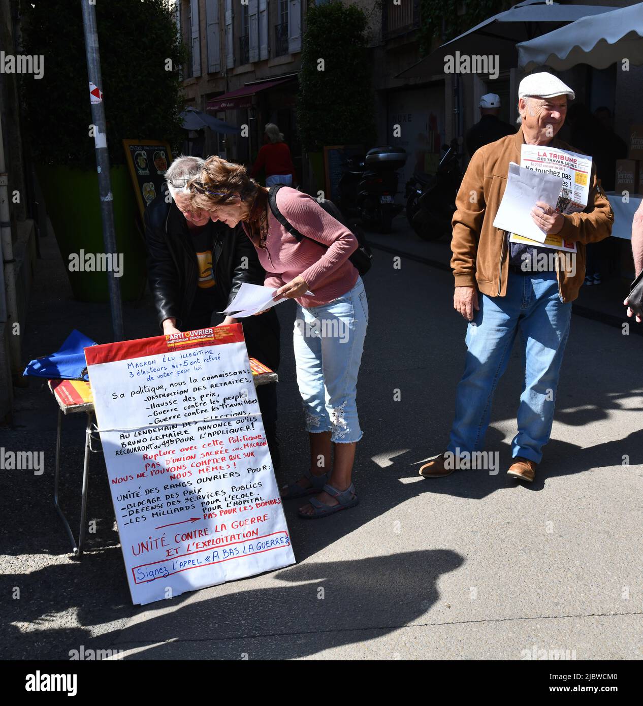 Persone che firmano una petizione politica con l'uomo che vende la Tribune des Travailleurs in Francia Foto Stock