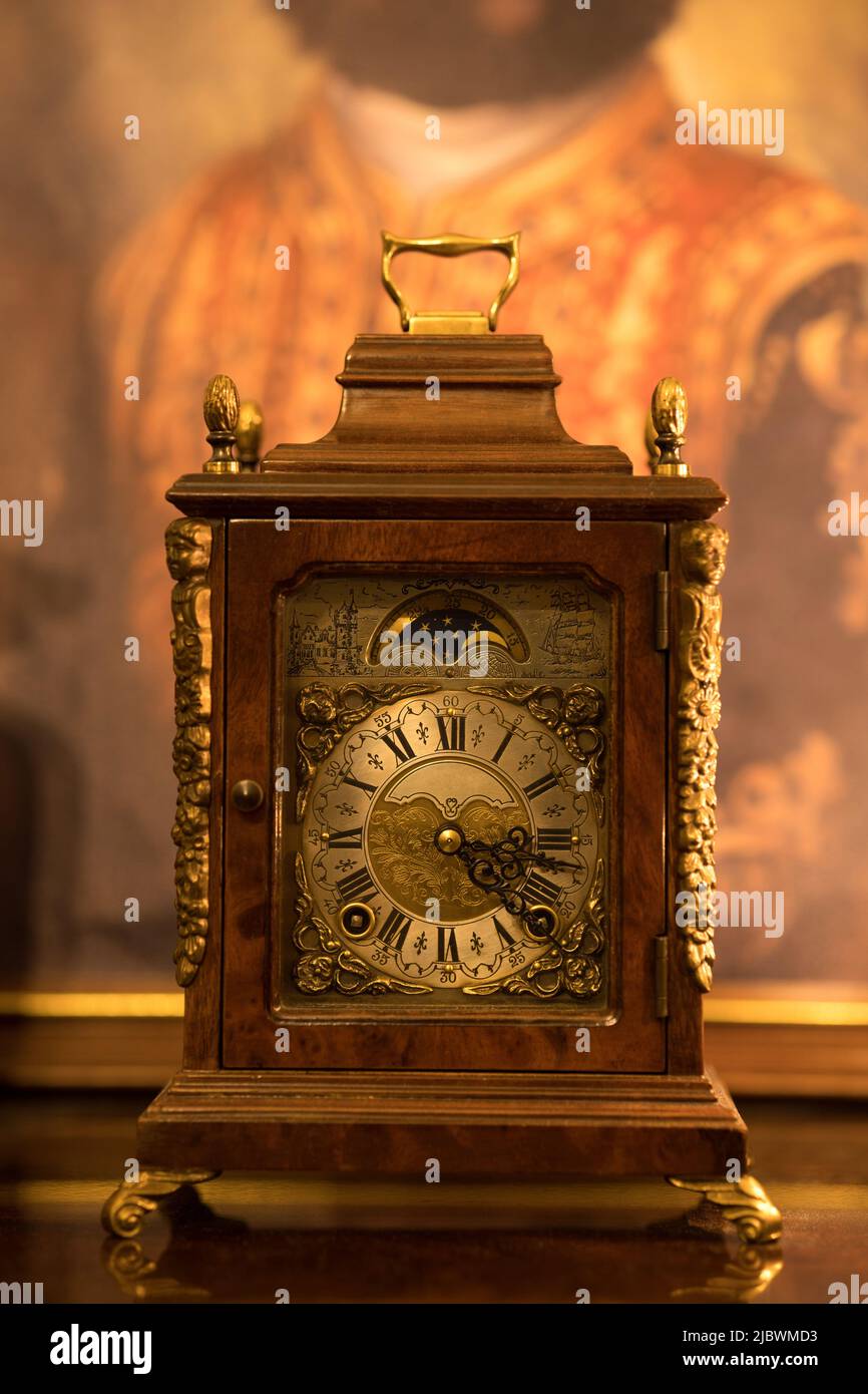 Isolato vecchio orologio da tavolo wind-up fatto nei Paesi Bassi con antico sfondo aspetto. Decorato orologio in legno d'epoca. Focalizzato sul quadrante dell'orologio. Wuba. Foto Stock