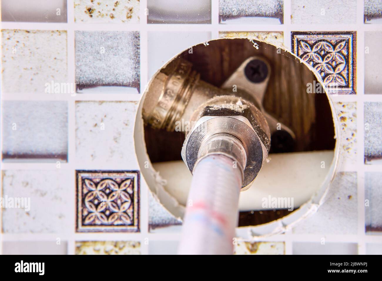 Tubo di collegamento intrecciato, tubo dell'acqua per l'alimentazione di acqua calda e fredda in casa rurale. Foto Stock