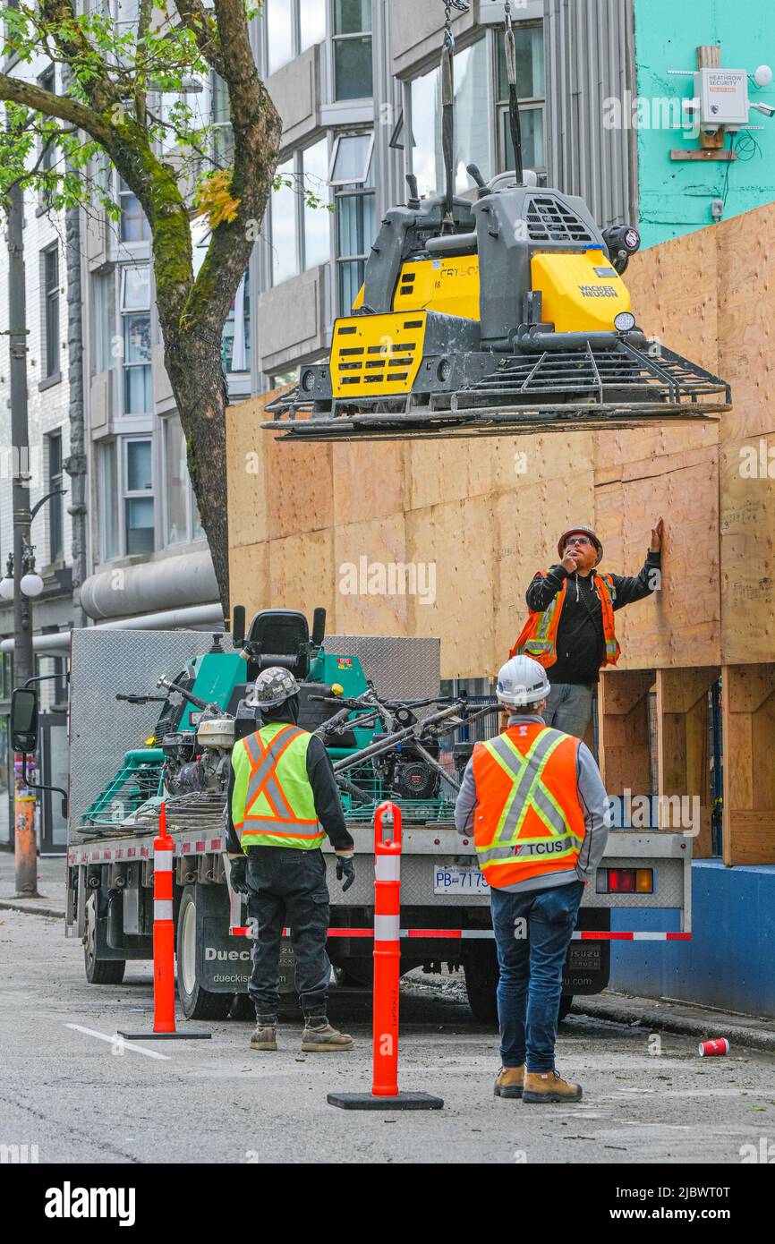 Wacker Neuson, Ride on Trowel, macchina per la finitura del calcestruzzo, in fase di abbassamento con gru in cantiere. Foto Stock