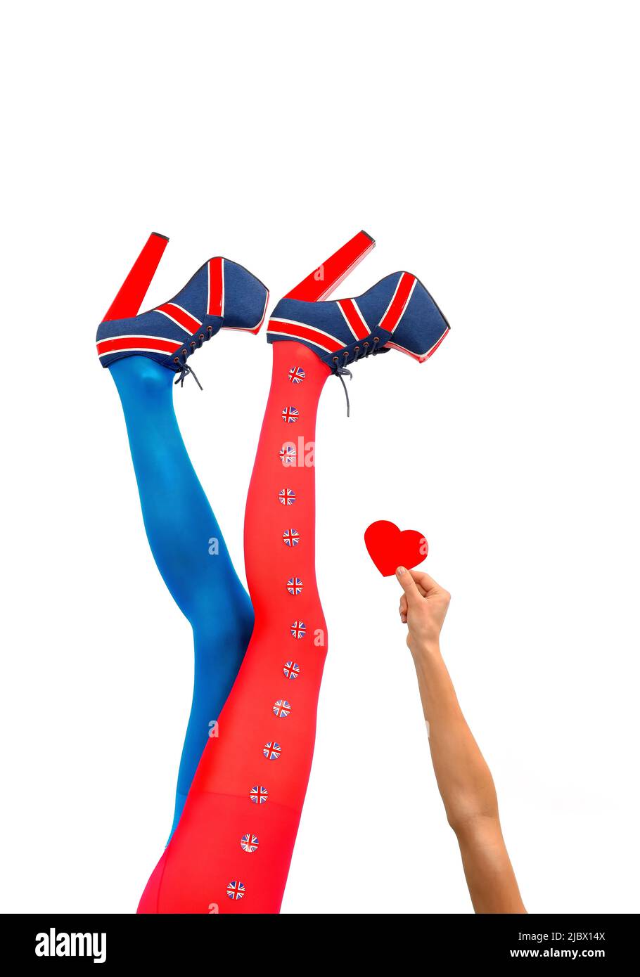 Le gambe femminili sono allungate in alto. Indossano tacchi alti con una bandiera britannica. Il braccio di una donna si allunga tenendo un cuore rosso. Foto Stock