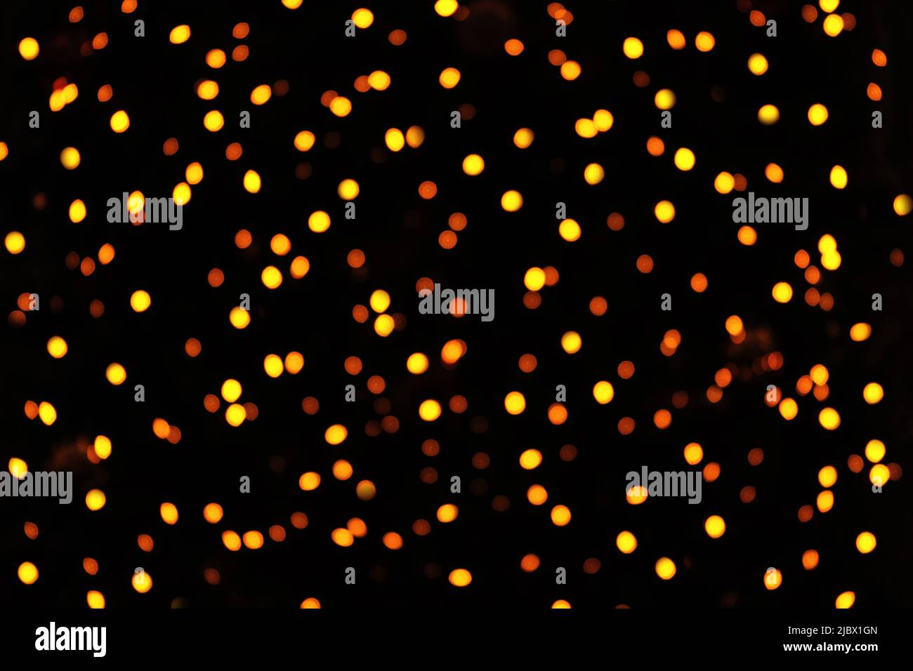 Natale oro sfocato bokeh luci su uno sfondo nero. Luci. Bagliore bokeh luminoso. Concetto di vacanza con luogo per il testo. Foto Stock