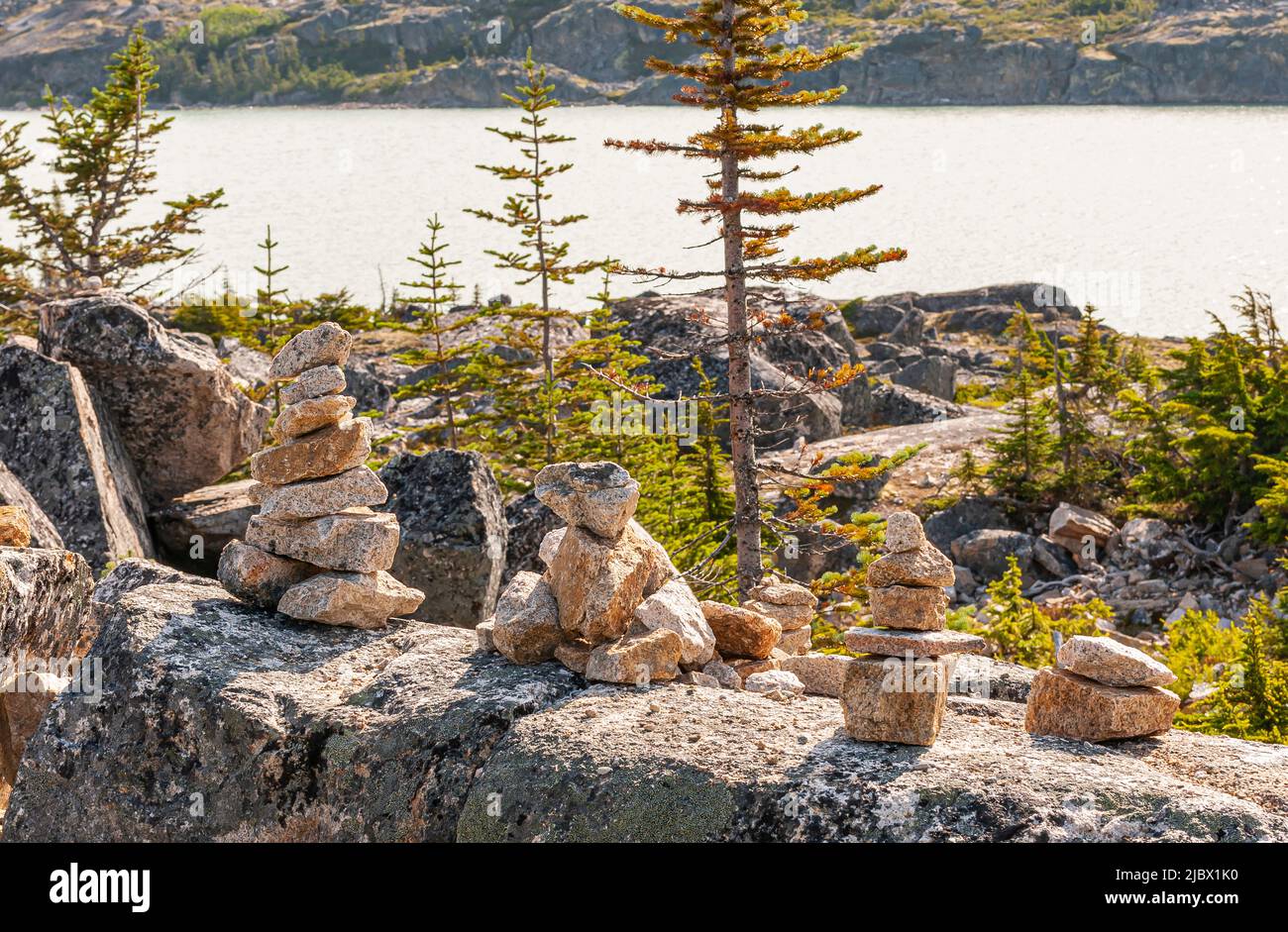 Skagway, Alaska, USA - 20 luglio 2011: Autostrada Klondike per il Canada. Esempi di bilanciamento della pietra a parete con lago d'argento Summer sul retro. Fogliame verde s Foto Stock