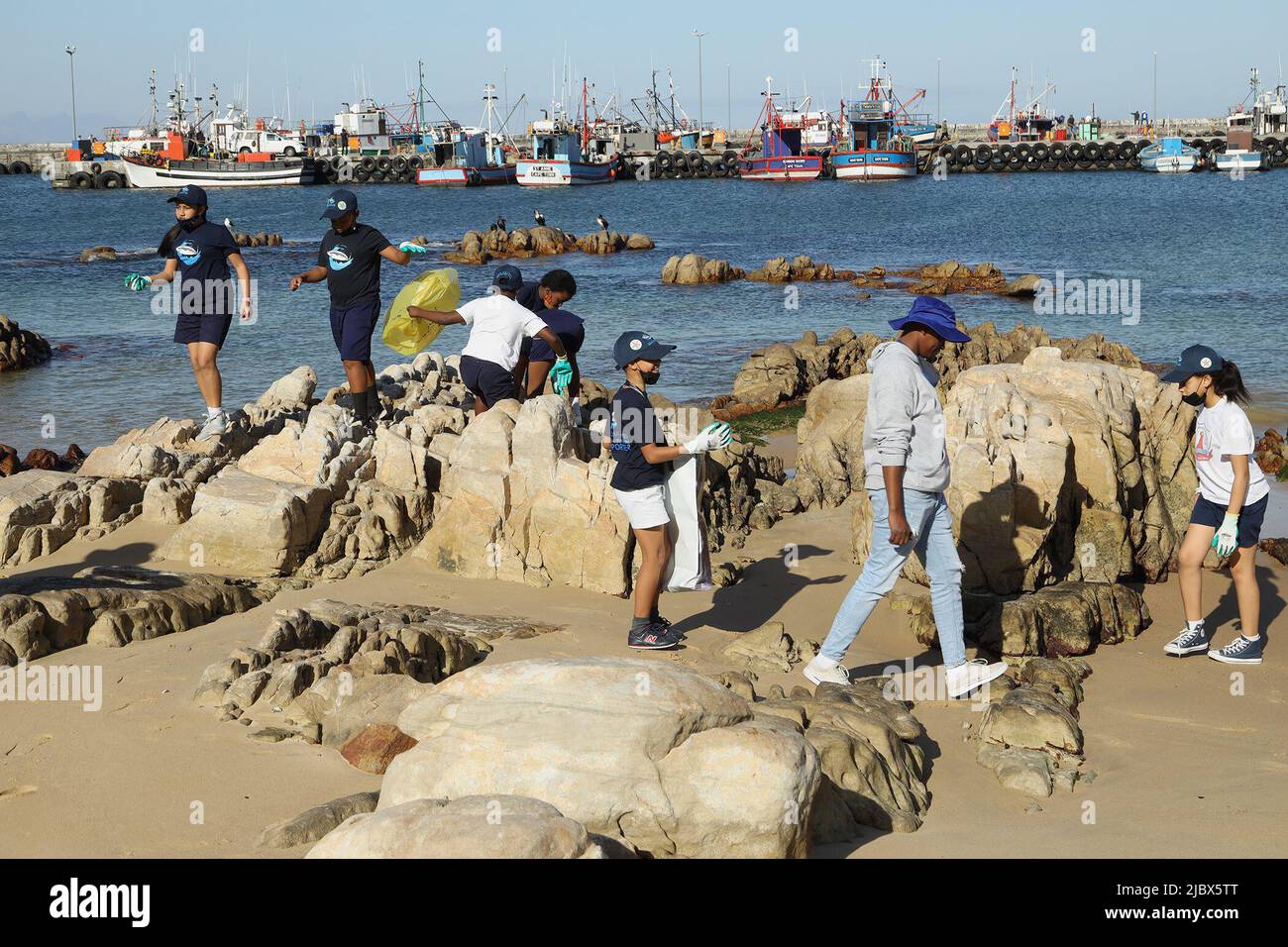 Città del Capo, Sudafrica. 8th giugno 2022. La gente del posto partecipa a una pulizia delle spiagge per celebrare la Giornata Mondiale degli oceani a Kalk Bay, Città del Capo, Sudafrica, il 8 giugno 2022. Nello spirito della comunità e dell'amore reciproco per il mare, il locale cafe Sirocco, la Save Our Seas Foundation (SOSF), il SOSF Shark Education Center e la Beach Co-op il mercoledì hanno ospitato congiuntamente la pulizia della spiaggia al Kalk Bay Harbor di Città del Capo. Credit: Francisco Scarbar/Xinhua/Alamy Live News Foto Stock