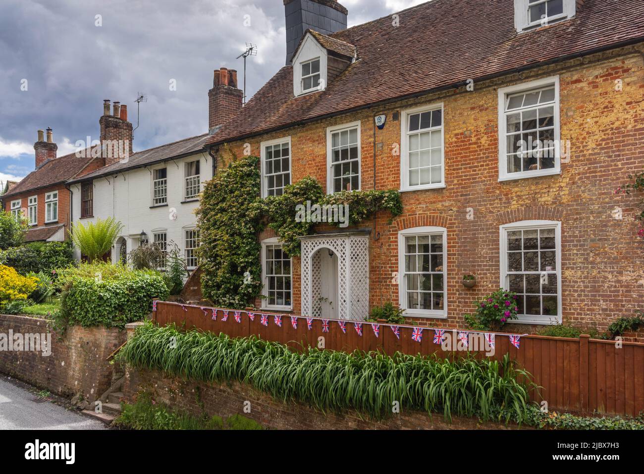 Una fila di pittoreschi cottage inglesi con Union Jack che si accatastano lungo Eling Hill a Eling - Totton, Southampton, Inghilterra, Regno Unito Foto Stock